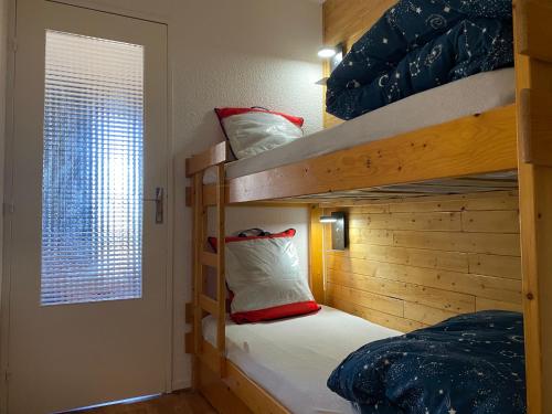 a bedroom with two bunk beds and a window at Studio Puy Saint Vincent 1600 aux pieds des pistes in Puy-Saint-Vincent