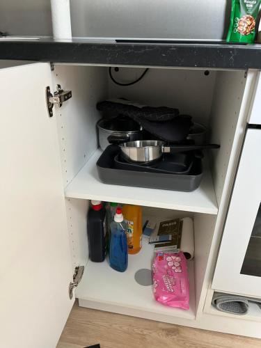 a kitchen shelf with a pot and pans at Studio de charme in Pantin