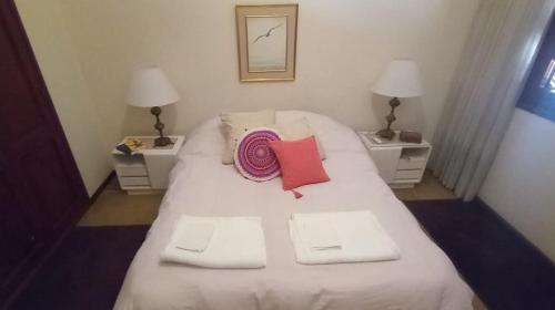a large white bed with two tables and two pillows at Mi habitación en Salta cerca de todo ! in Salta