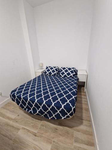 a bed with a blue and white comforter in a room at ESTACIÓN JOAQUÍN SOROLLA MyHomeStay in Valencia