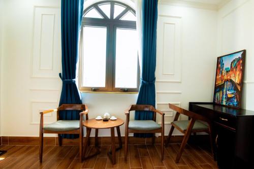 a room with chairs and a table and a window at HÀ ANH hotel in Phường Sáu