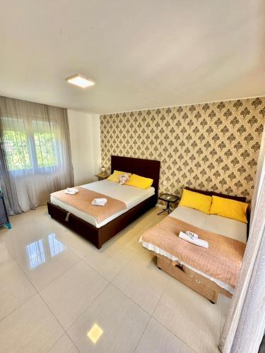 a bedroom with two beds with yellow pillows at Montenegrina Apartment in Budva