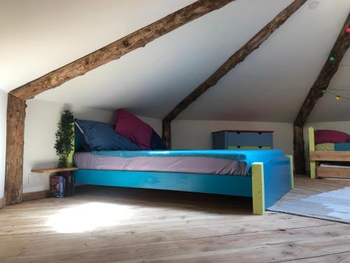 a bedroom with a blue bed in a attic at CVN écologîtes in Saint-André-de-Majencoules