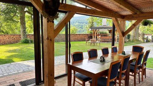 a wooden table and chairs on a patio at Penzion Zvonice Hojná Voda in Horní Stropnice