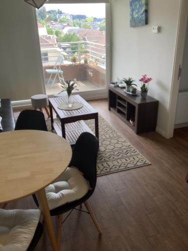 uma sala de estar com uma mesa e cadeiras e uma varanda em Departamento en condominio de villarrica em Villarrica