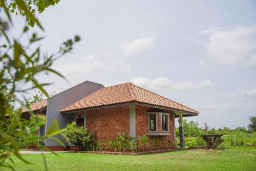 een klein bakstenen huis in een grasveld bij Foresta Resort Sigiriya in Sigiriya