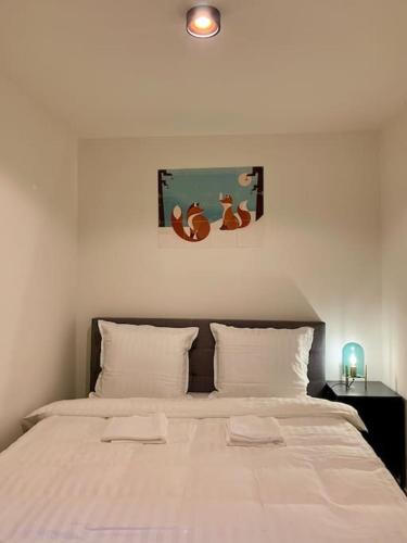 a bedroom with a large white bed with two pillows at Sluwe Vos: ontspannen in het bos! in Otterlo