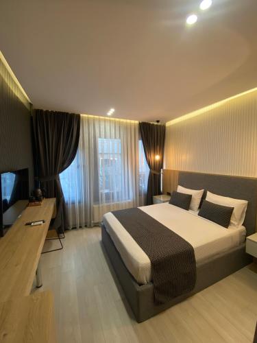 Santra Bosphorus Hotel في إسطنبول: غرفة نوم بسرير ومكتب وتلفزيون
