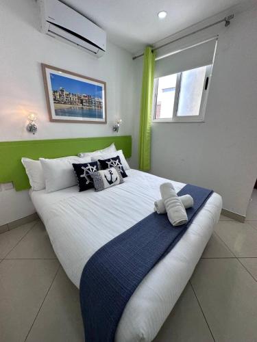 a large bed in a bedroom with green accents at The Beach House in Birżebbuġa