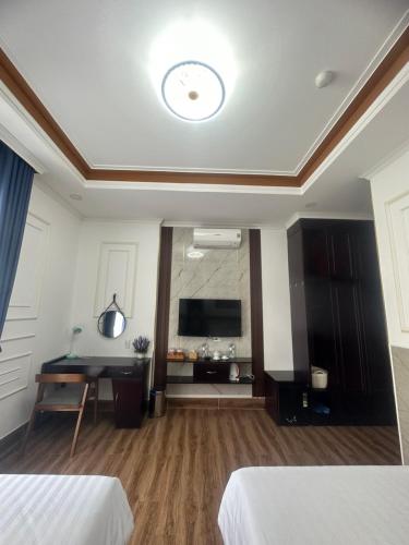 a room with two beds and a flat screen tv at HÀ ANH hotel in Phường Sáu