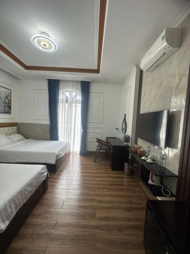 a hotel room with two beds and a television at HÀ ANH hotel in Phường Sáu
