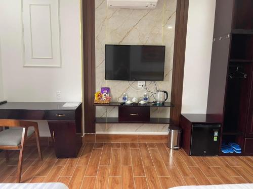 a living room with a flat screen tv on a wall at HÀ ANH hotel in Phường Sáu