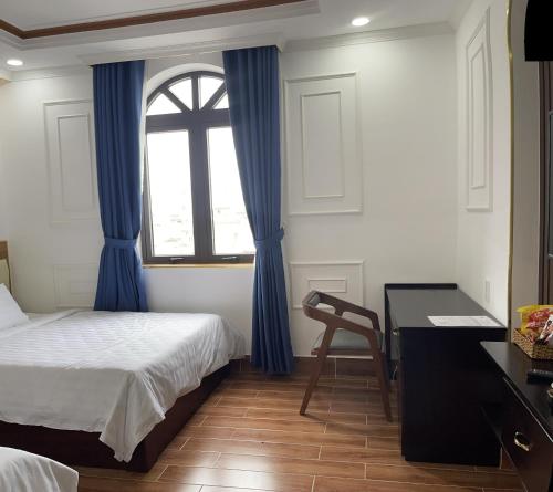 a bedroom with a bed and a desk and a window at HÀ ANH hotel in Phường Sáu