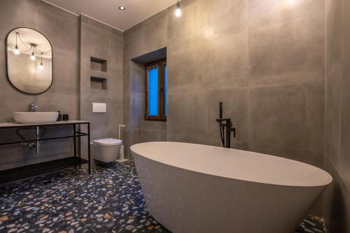 een badkamer met een groot bad en een wastafel bij City Premium Heritage in Zadar