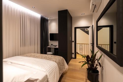a bedroom with a white bed and a mirror at City Premium Heritage in Zadar