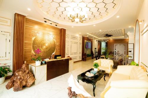 a living room with white furniture and a chandelier at HÀ ANH hotel in Phường Sáu
