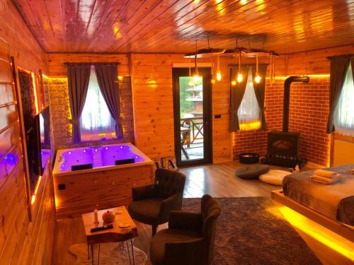 a living room with a tub and a bedroom at Ria süit otel bungalov in Rize