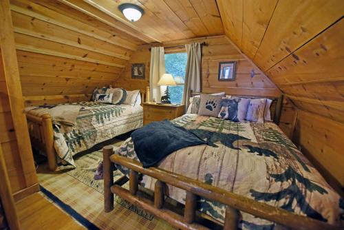 1 dormitorio con 2 camas en una cabaña de madera en Big Pine - Long range mountain views, large decks, hot tub, fire pit and dog friendly!, en Blairsville