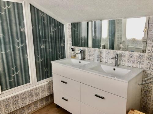 a bathroom with two sinks and a mirror at Chalet al lado de la playa con piscina privada, jardín y barbacoa, frontón, 6 HABITACIONES in Laredo