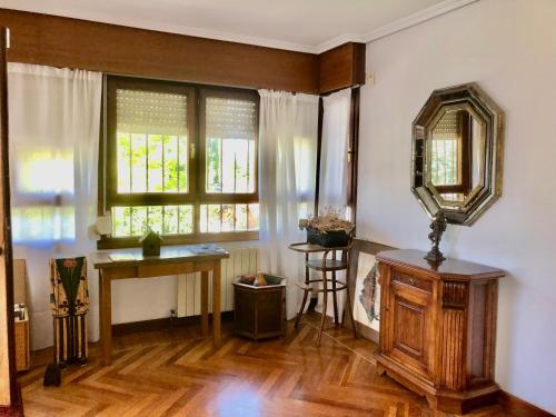 uma sala de estar com uma mesa e um espelho em Chalet al lado de la playa con piscina privada, jardín y barbacoa, frontón, 6 HABITACIONES em Laredo