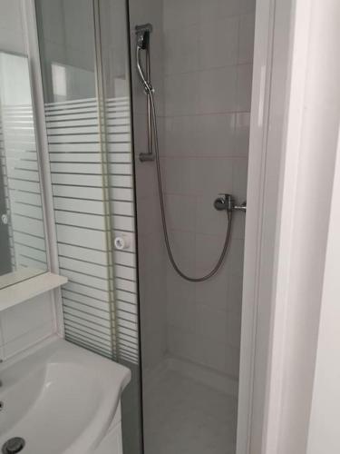 La salle de bains blanche est pourvue d'une douche et d'un lavabo. dans l'établissement Villette, à Aubervilliers