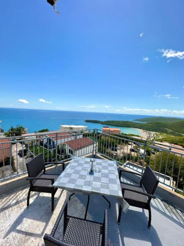 stół i krzesła na balkonie z widokiem na ocean w obiekcie Montenegrina Apartment w Budvie