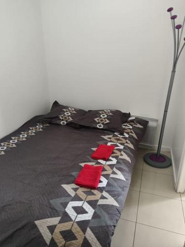 a bed with two red pillows on top of it at Villette in Aubervilliers