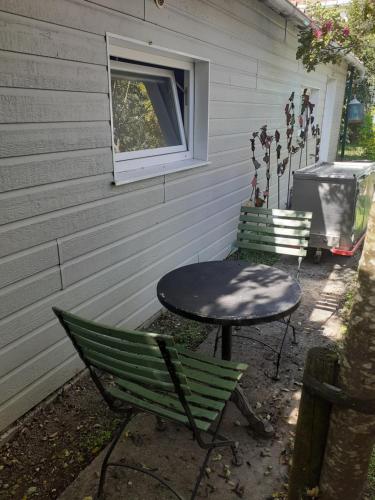 une table et des chaises assises à l'extérieur d'une maison dans l'établissement Le nid du parc, à Nantes