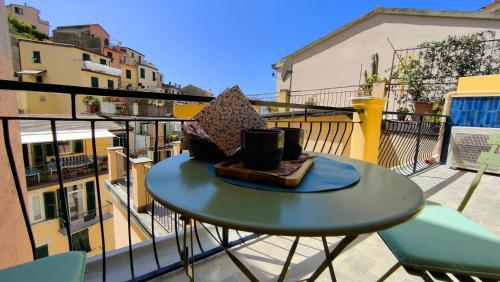 a table on a balcony with two cups on it at La Grigua blu in Riomaggiore