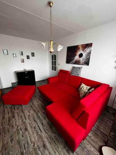 een woonkamer met een rode bank en een televisie bij Ubytování na festival Brutal Assaut in Jaroměř