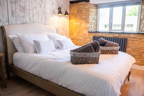 a bedroom with a bed with two baskets on it at 2 Candlemas Cottage in Bourton on the Water
