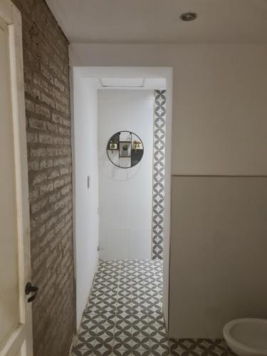 a bathroom with a white door and a tile floor at La Boutique Aparts Temporarios Corrientes Pleno centro in Corrientes