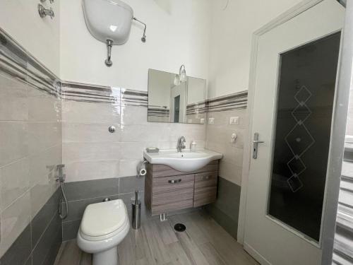 a bathroom with a toilet and a sink and a mirror at Vista Lago in Bacoli