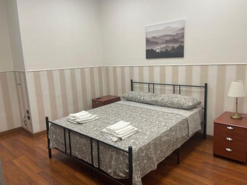 ein Schlafzimmer mit einem Bett und einem Tisch mit Handtüchern in der Unterkunft Vista Lago Bacoli in Bacoli