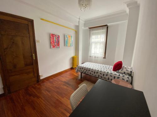 Habitación con sofá, mesa y ventana en Habitación individual Juan florez A Coruña en A Coruña