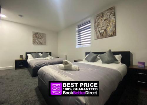 a hotel room with two beds with a sign that reads best price guaranteed at Hotel Royal in Blackburn