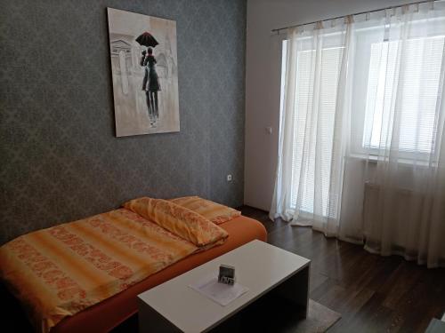 a bedroom with a bed and a table in it at Apartment Ivi034 Kragujevac in Kragujevac