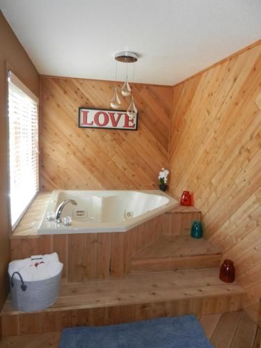 a bath tub in a room with a wooden wall at Great Northern Hotel in Mercer