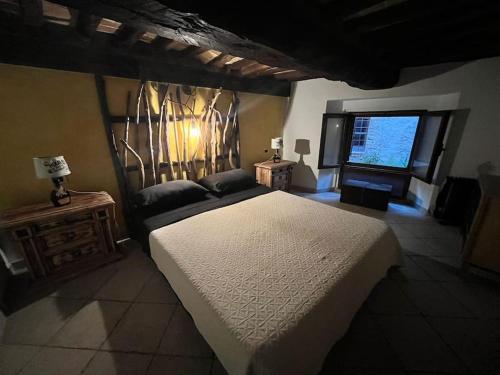 a bedroom with a large bed and a window at La Casina - Borgo di Bibbona in Bibbona