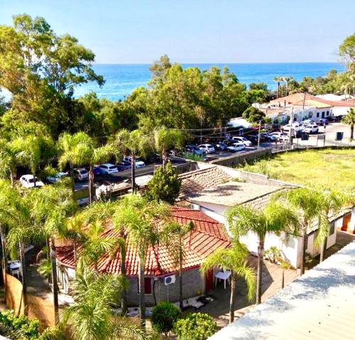 an aerial view of a parking lot with palm trees and the ocean at Frontemare Residence in Fiumefreddo di Sicilia