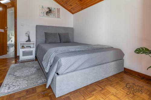 ein Schlafzimmer mit einem großen Bett und Holzboden in der Unterkunft Cantinho dos Avós in Viana do Castelo