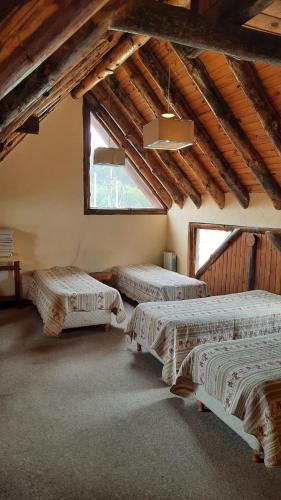 a room with three beds and a large window at Antu in Caviahue