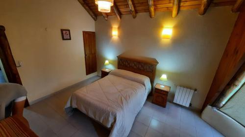 a bedroom with a bed and two lights on the wall at Antu in Caviahue