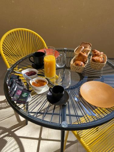 a glass table with breakfast foods and orange juice on it at CASA JOSEPHINE in Serra-di-Ferro