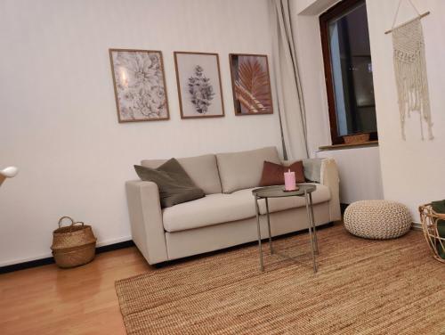 ein Wohnzimmer mit einem Sofa und einem Tisch in der Unterkunft Bliss - 3 Zimmer, Boho, Arbeitsplatz, Netflix in Gießen