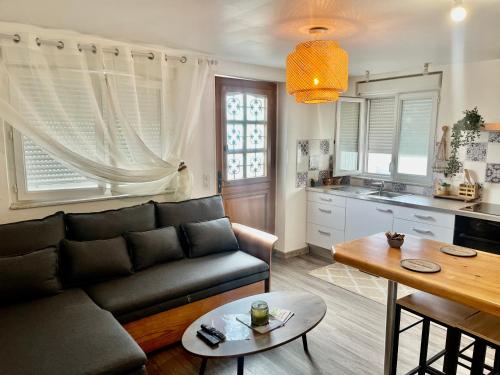 ein Wohnzimmer mit einem Sofa und einem Tisch in der Unterkunft le petit prince , jolie maisonnette terrasse Netflix parking privé jeux de société in Bourg-en-Bresse