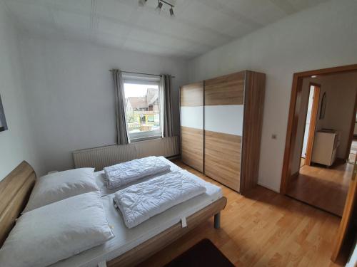1 dormitorio con 1 cama con sábanas blancas y ventana en Mikes Fewo en Braunlage