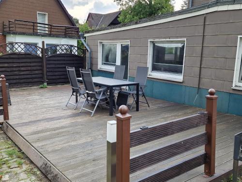 una terraza de madera con mesa y sillas. en Mikes Fewo en Braunlage