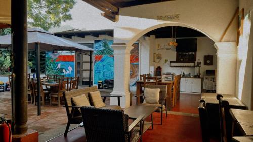 um restaurante com mesas e cadeiras e uma cozinha em Hostal Antigüeño em Antigua Guatemala