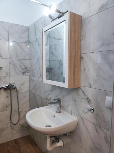 a white bathroom with a sink and a mirror at Giorgio studios in Kokkari